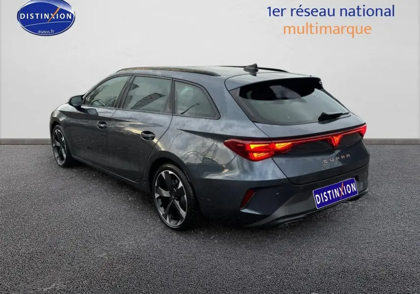 Vue 3/4 arrière droite d'une CUPRA Leon ST gris magnétique avec feux arrière LED allumés et jantes alliage.