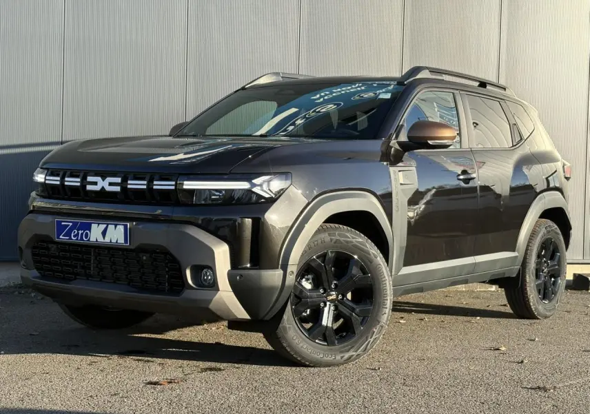 Dacia Duster noir nacré en 3/4 avant droit, avec jantes alliage noires et coques de rétroviseur brun cuivré.