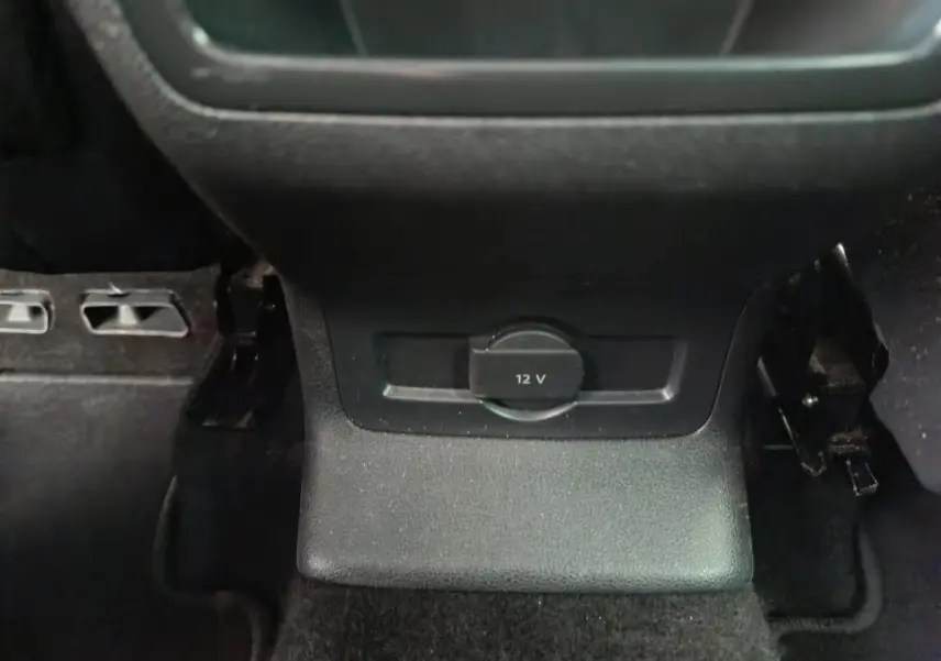Prise 12V noire en gros plan sur la console centrale arrière d'un Skoda Karoq blanc 2024.