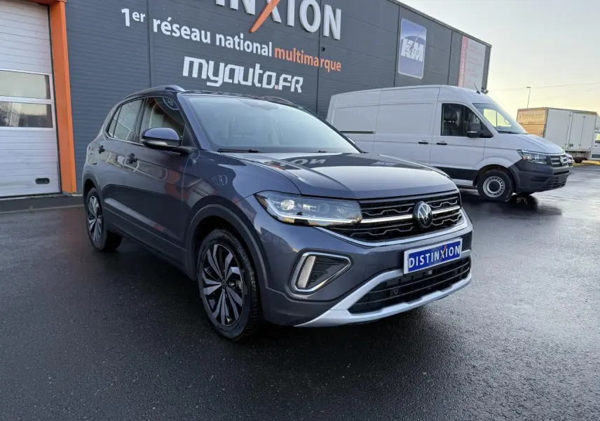 Volkswagen T-Cross gris cendre en 3/4 avant droit, avec calandre chromée et jantes alliage distinctives.