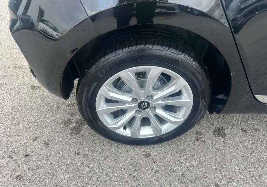 Gros plan sur la roue avant droite d'une Renault Clio noire 2025, mettant en valeur la jante argentée au design moderne.