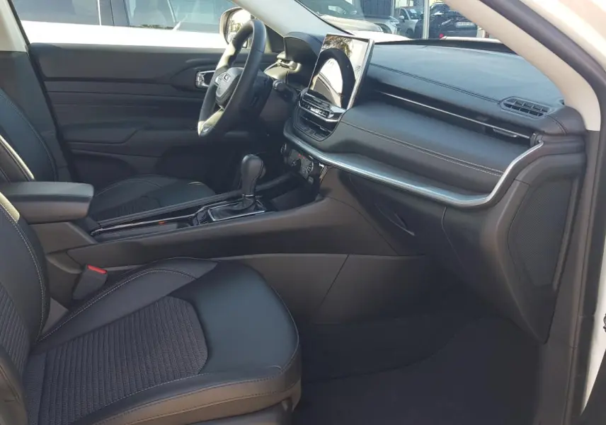 Vue intérieure côté passager du Jeep Compass blanc 2024, montrant sièges noirs, console centrale et écran tactile.