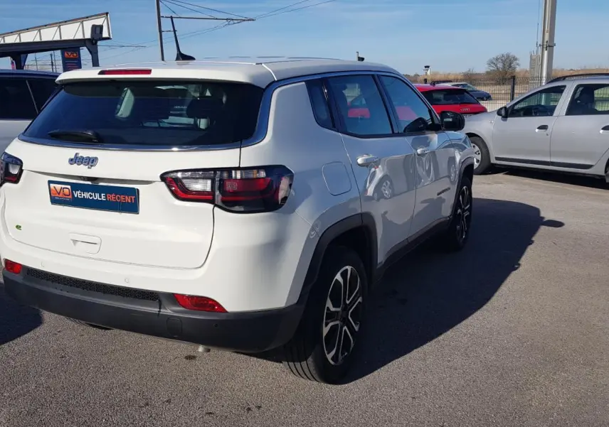 Jeep Compass blanc vu en 3/4 arrière droit, avec jantes alliage 18 pouces et feux arrière LED.