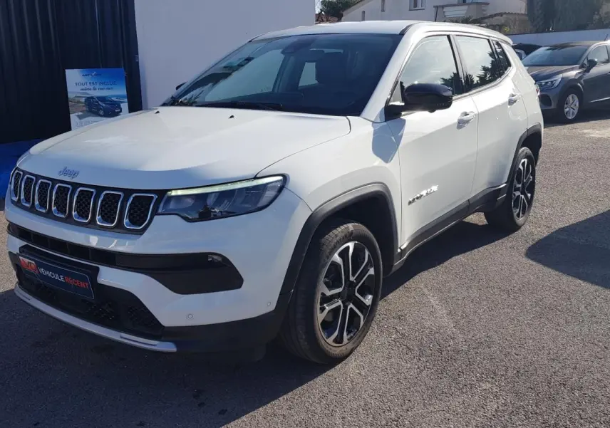 Jeep Compass blanc en 3/4 avant droit, avec jantes alliage 18 pouces et calandre distinctive à sept fentes.
