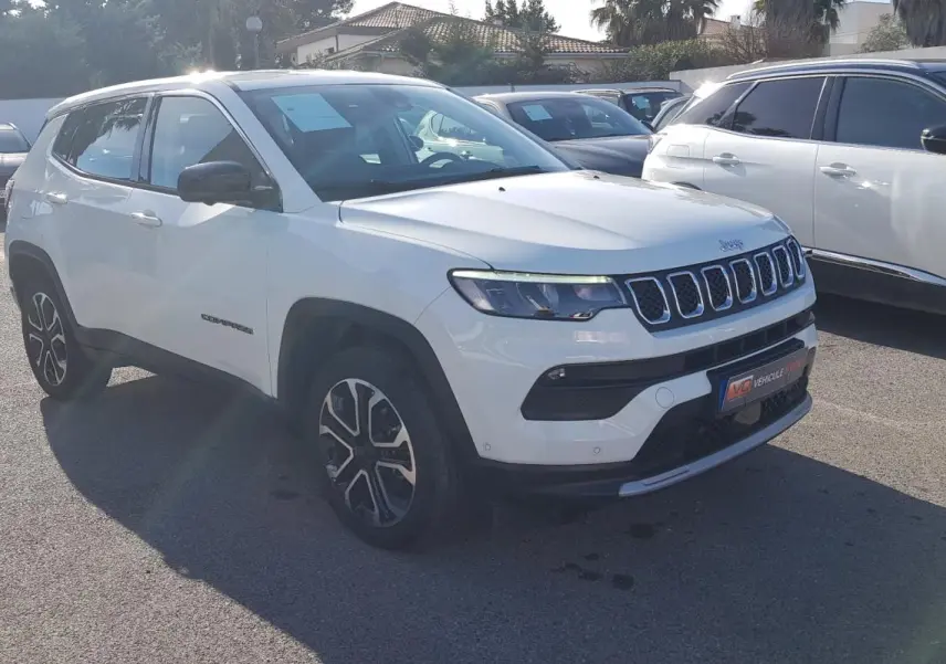 Jeep Compass blanc en 3/4 avant droit, avec jantes alliage 18 pouces et calandre distinctive à sept fentes.