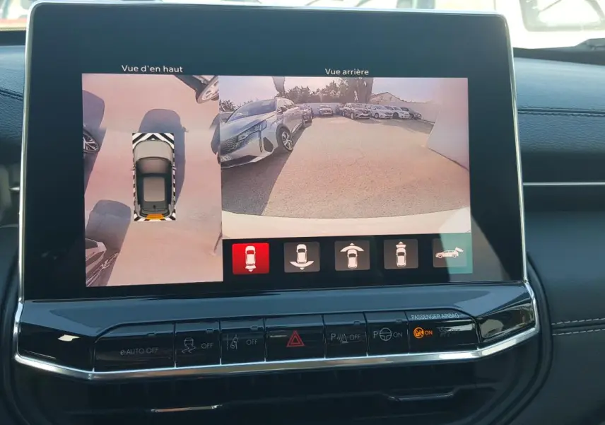 Écran tactile intérieur montrant la caméra de recul et la vue aérienne du Jeep Compass blanc 2024.