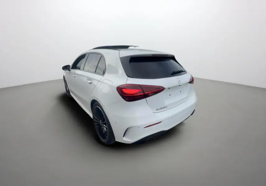 Vue 3/4 arrière gauche d'une Mercedes Classe A 200D blanche polaire avec toit panoramique noir et jantes alu noires.