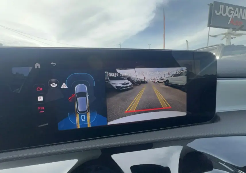 Écran de caméra de recul d'une Mercedes Classe A 200D blanche, affichant la vue arrière avec lignes de guidage jaunes.