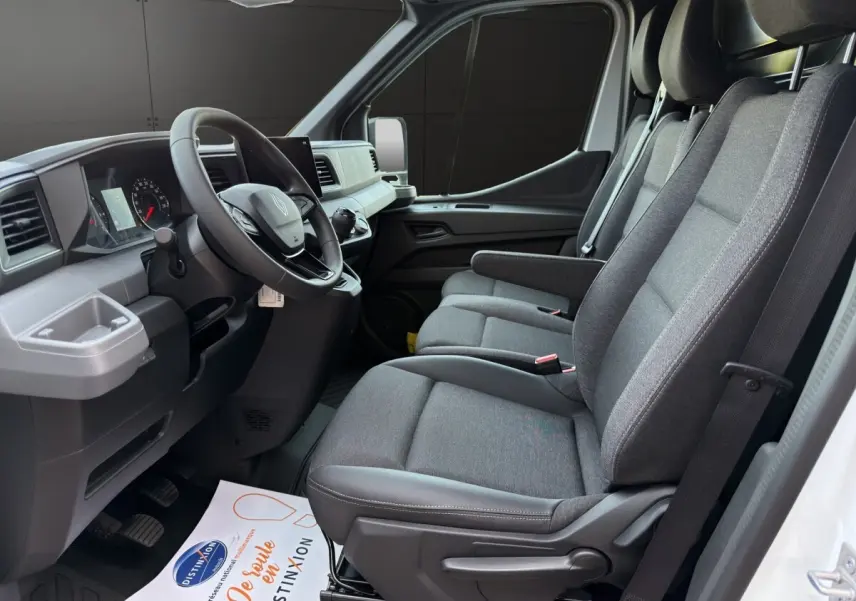 Vue intérieure côté conducteur du Renault Master 2026 avec sièges gris, volant réglable et tableau de bord moderne.