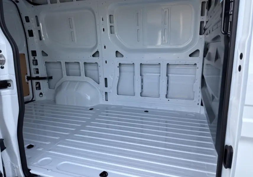 Vue intérieure arrière du fourgon blanc Renault Master FG L2H2, montrant l'espace de chargement vide et la cloison pleine.