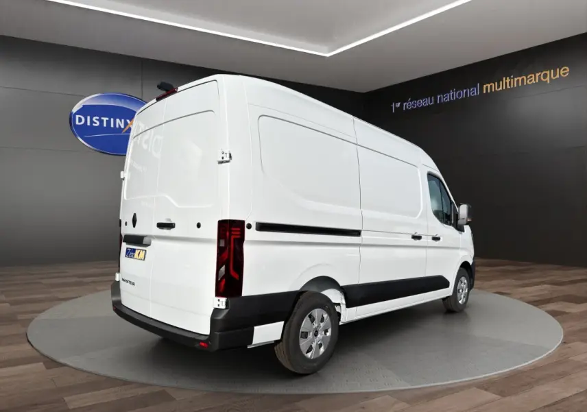Vue 3/4 arrière droite du Renault Master blanc avec feux arrière LED et protections noires sur les bas de caisse.