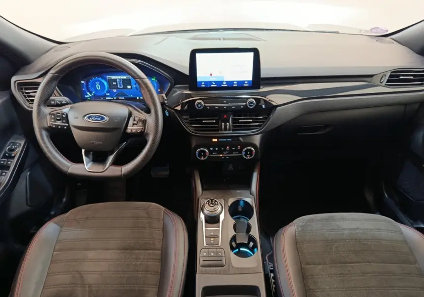 Vue intérieure avant du Ford Kuga 2023 gris foncé, tableau de bord moderne avec écran tactile central et volant multifonctions.