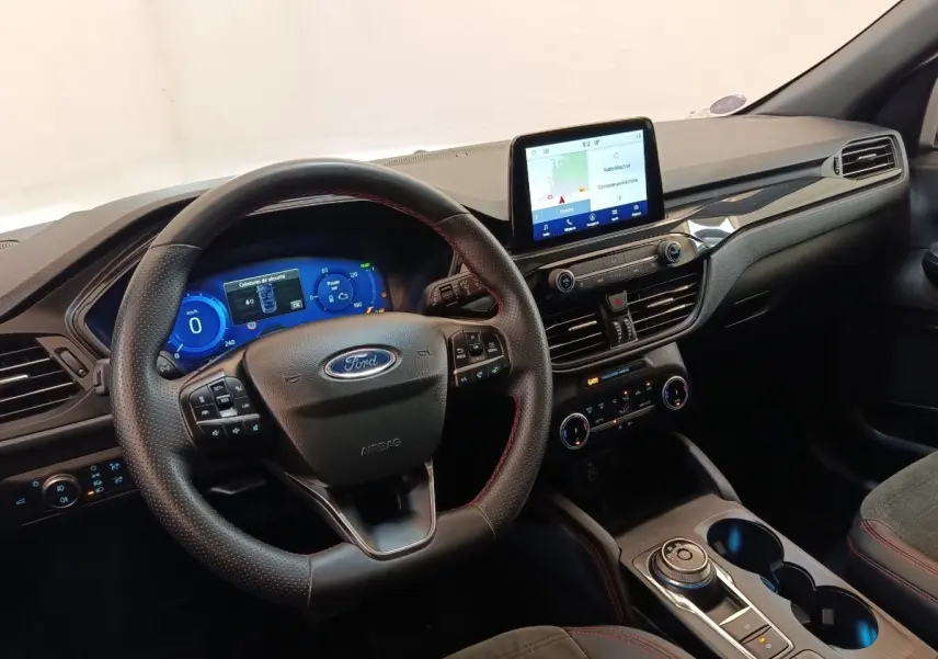Vue intérieure du tableau de bord et volant cuir noir avec surpiqûres rouges du Ford Kuga gris foncé 2023.