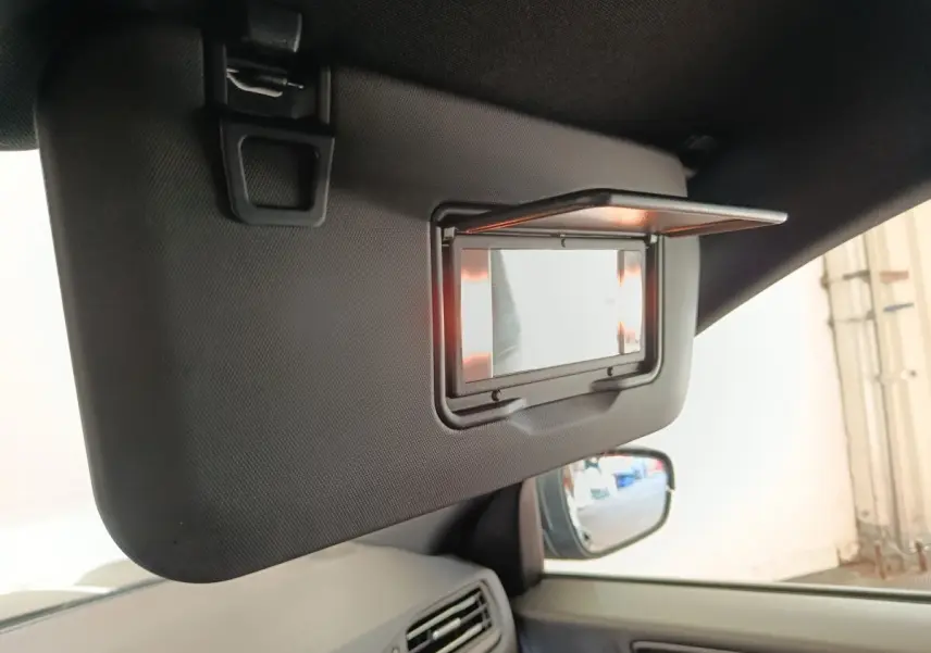 Détail du pare-soleil côté conducteur avec miroir éclairé, intérieur gris foncé du Ford Kuga 2023.