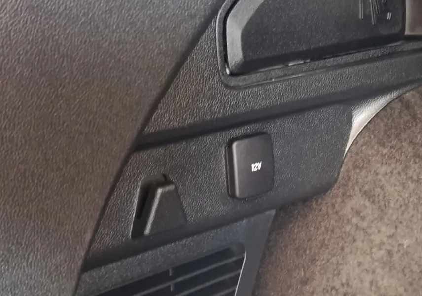 Gros plan sur prise 12V et crochet d’arrimage dans le coffre du Ford Kuga gris foncé 2023.