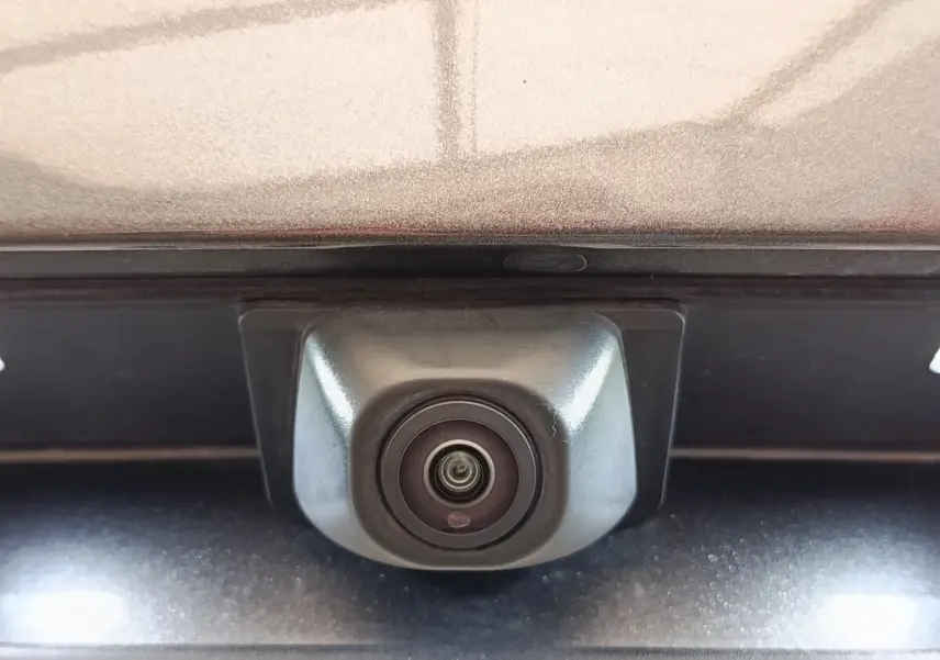 Gros plan sur la caméra de recul intégrée au hayon gris foncé du Ford Kuga 2023, version hybride ST-Line X.