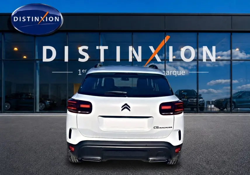 Vue arrière du Citroën C5 Aircross blanc 2025 avec feux arrière LED et barres de toit visibles.