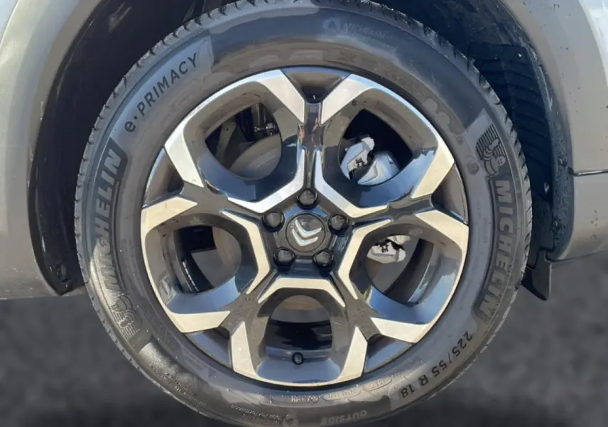 Gros plan sur la jante alu bicolore et le pneu Michelin d'un Citroën C5 Aircross blanc, côté avant droit.