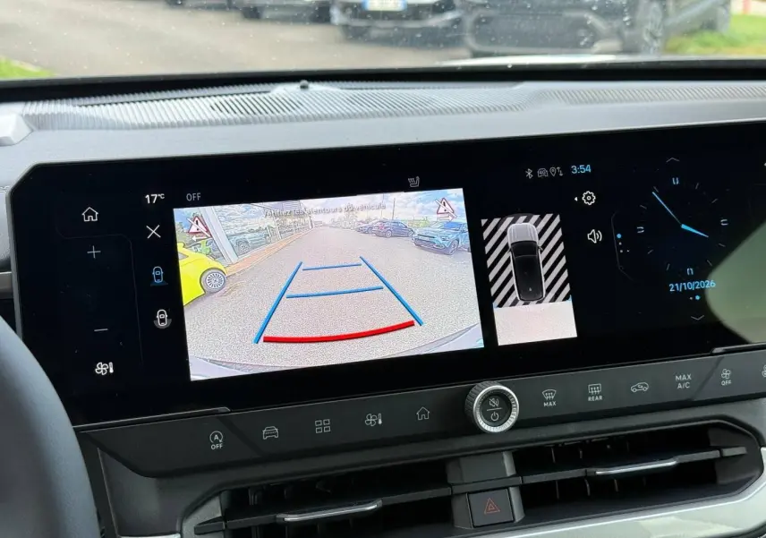 Vue intérieure du tableau de bord du Jeep Compass 2026 avec écran tactile affichant la caméra de recul et les commandes climatiques.