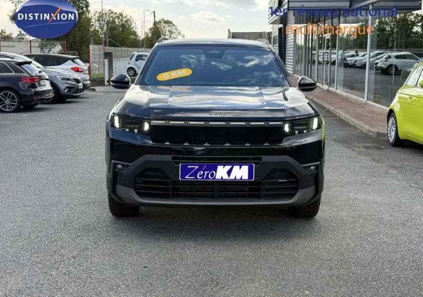 Vue avant d'un Jeep Compass 2026 couleur Vulcano, avec calandre noire et phares LED allumés.