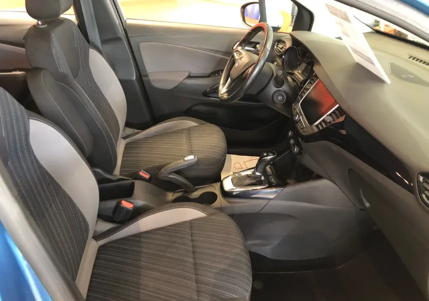 Vue intérieure côté conducteur de l'Opel Crossland X bleu intens métal, montrant sièges tissu noir et console centrale avec boîte automatique.