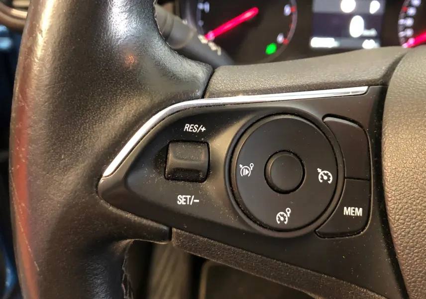Gros plan sur les commandes de régulateur de vitesse au volant noir de l'Opel Crossland X 2019.