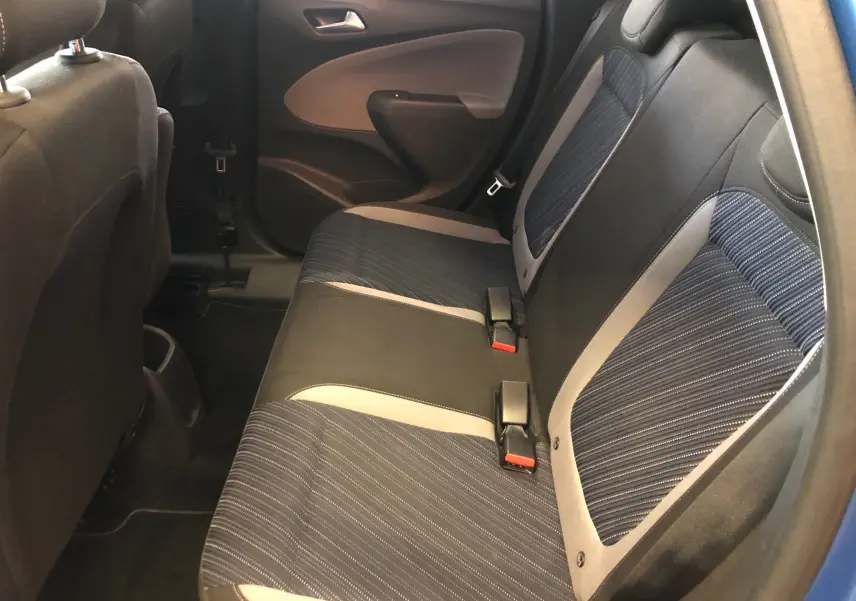 Vue intérieure côté arrière droit montrant les sièges arrière en tissu noir et bleu de l'Opel Crossland X 120 Ans.