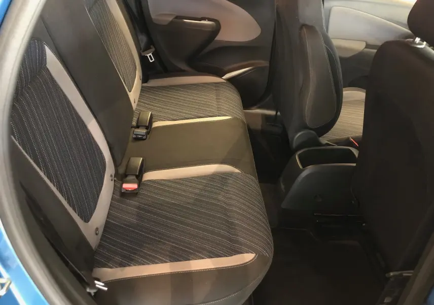 Vue intérieure côté arrière gauche de l'Opel Crossland X bleu intens métal, sièges tissu noir avec surpiqûres grises.