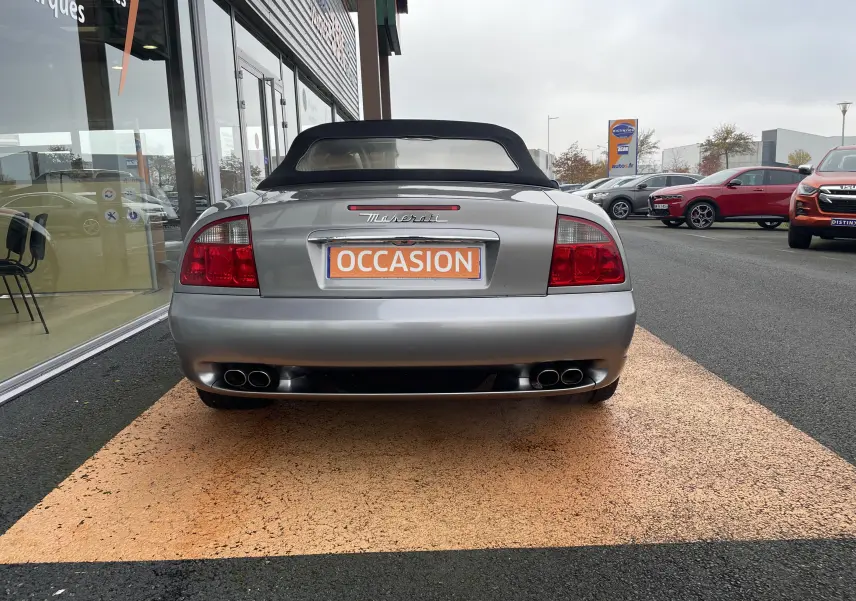 Vue arrière d'une Maserati Spyder gris Nuvolari de 2002 avec capote noire et double sortie d'échappement quadruple.