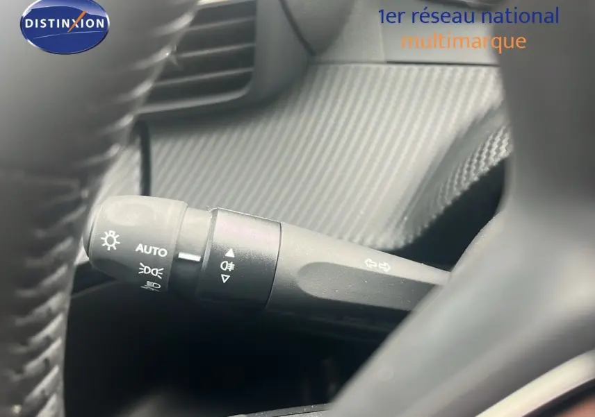 Gros plan sur la commande des feux et clignotants du Peugeot 2008 blanc, visible depuis le volant côté gauche.