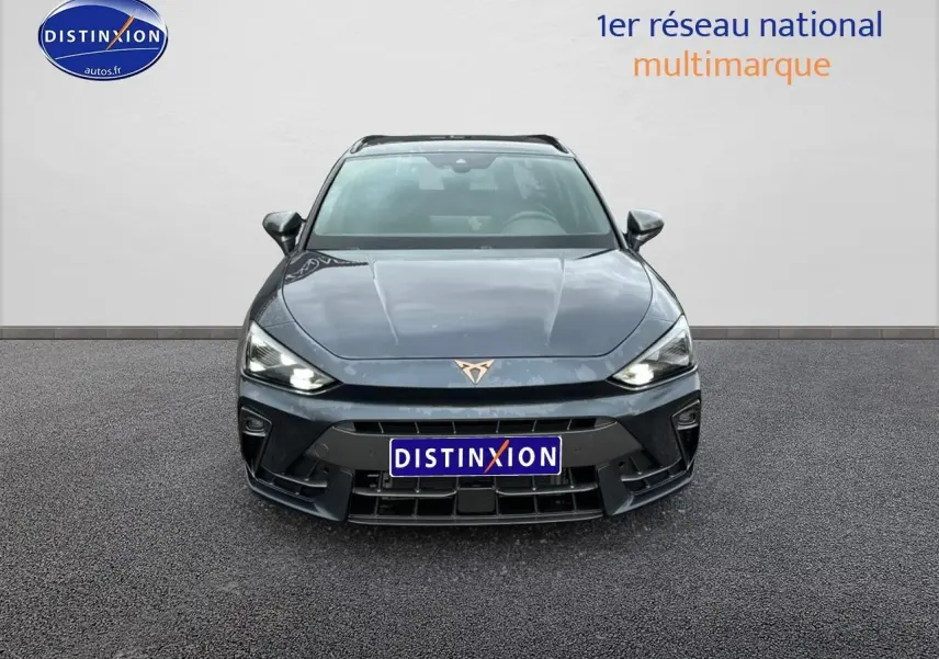 Vue frontale d'une CUPRA LEON ST 1.5 etsi hybrid 2025 en gris magnétique avec phares LED allumés.