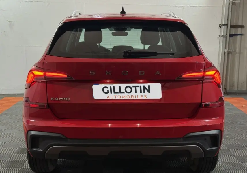 Vue arrière d'un Skoda Kamiq rouge 2024 avec feux LED allumés et logo visible sur un sol en damier.