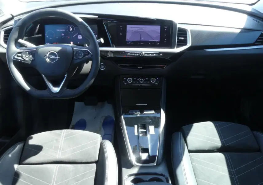 Vue intérieure avant de l’Opel Grandland 2024, tableau de bord noir avec écran tactile et sellerie Alcantara noire.