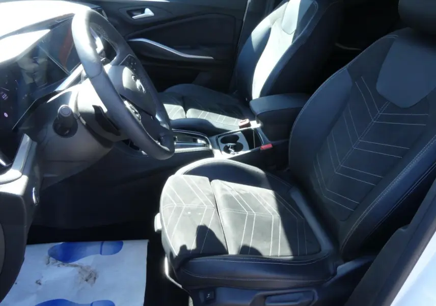 Vue intérieure côté conducteur de l’Opel Grandland 2024, sièges en Alcantara noir avec surpiqûres blanches.