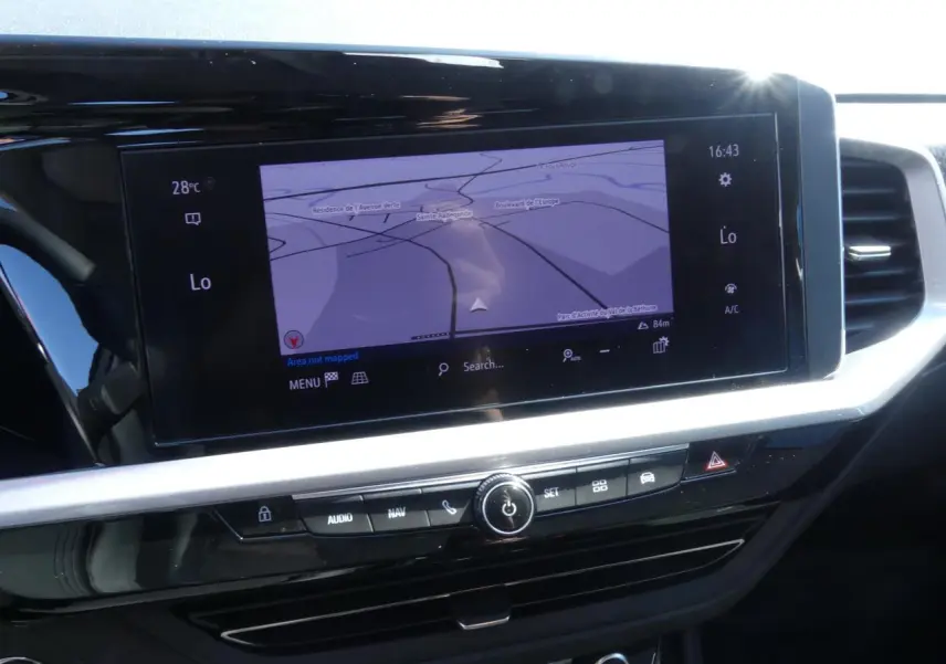 Écran tactile central du tableau de bord de l’Opel Grandland blanc, affichant la navigation GPS en plein jour.