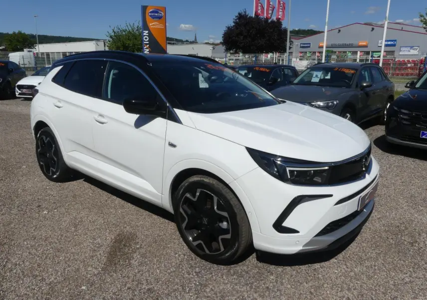 Opel Grandland blanc métallisé en 3/4 avant droit avec toit noir et jantes alliage noires.