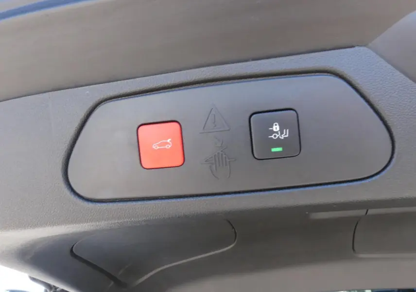 Gros plan sur les boutons d'ouverture mains-libres du hayon du coffre du Opel Grandland blanc métallisé 2024.