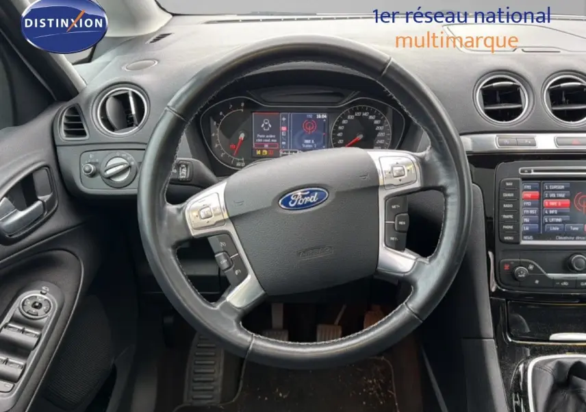 Vue intérieure centrée sur le volant noir du Ford S-MAX 2013 avec tableau de bord et console centrale visibles.