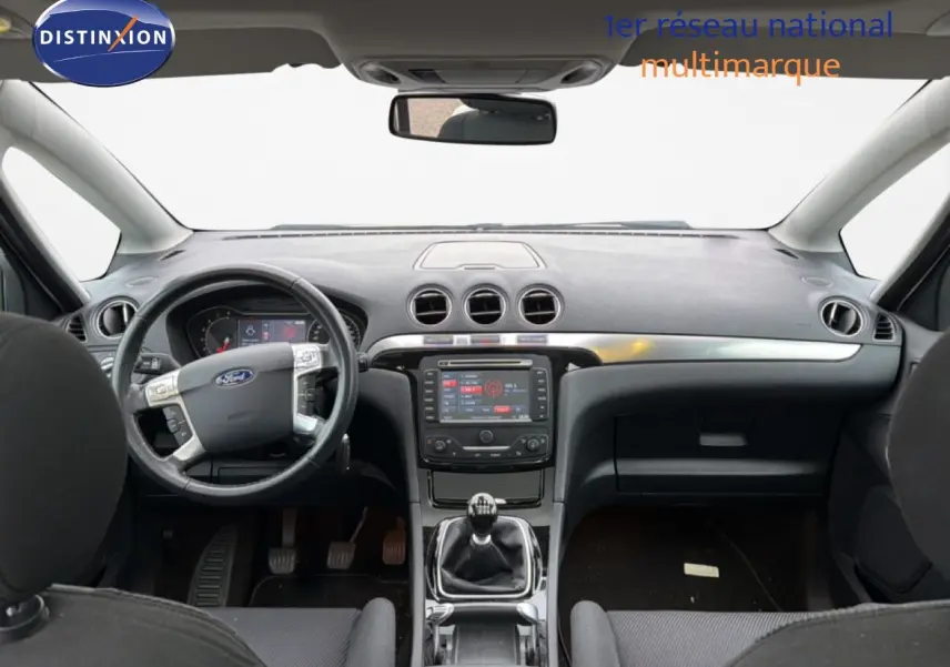 Vue intérieure avant du Ford S-MAX 2013 avec tableau de bord noir, volant multifonction et boîte manuelle.