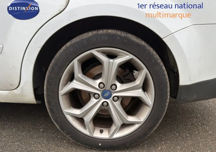 Gros plan sur la roue arrière droite d’une Ford S-MAX blanche de 2013 avec jante alliage 18 pouces.