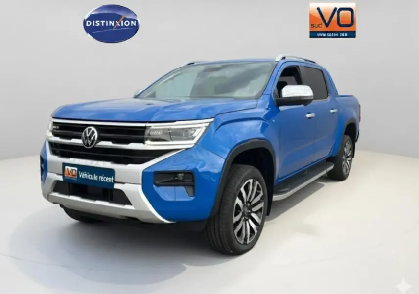 Vue 3/4 avant droite du Volkswagen Amarok bleu avec jantes alliage 21 pouces et marchepieds visibles.