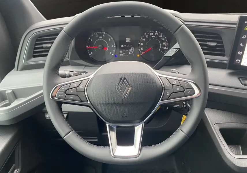 Vue frontale du volant noir de Renault Master 2025 avec commandes intégrées et tableau de bord numérique.