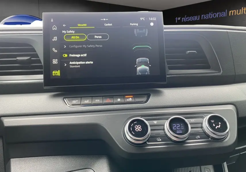 Vue rapprochée du tableau de bord du Renault Master blanc 2025, mettant en valeur l'écran tactile et les commandes de climatisation.