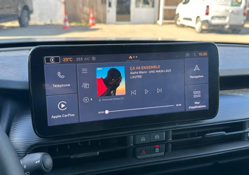 Écran tactile central du tableau de bord du Jeep Avenger gris, affichant la musique et les options connectées.