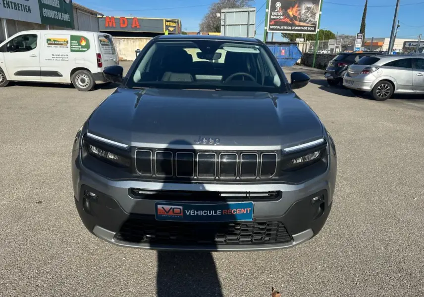 Vue frontale d'un Jeep Avenger gris 2025 avec calandre à sept ouvertures et phares LED fins.