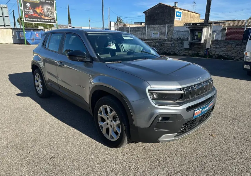 Jeep Avenger gris en 3/4 avant droit, mettant en valeur ses jantes alliage 17 pouces et ses phares LED distinctifs.