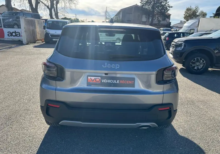 Vue arrière d’un Jeep Avenger gris 2025 avec feux arrière fumés et plaque « Véhicule récent » visible.