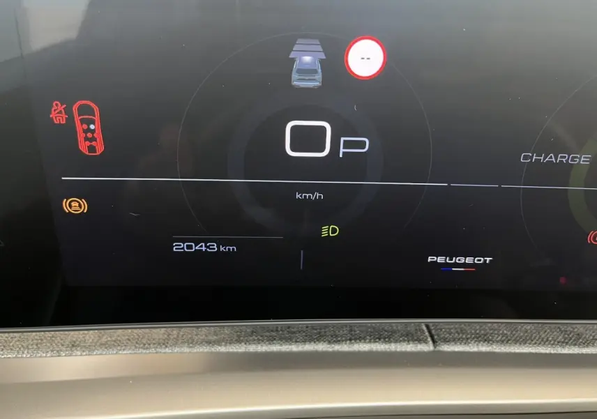 Affichage numérique du combiné d'instruments du Peugeot 5008 Hybrid blanc, montrant 2043 km et indicateurs de sécurité.