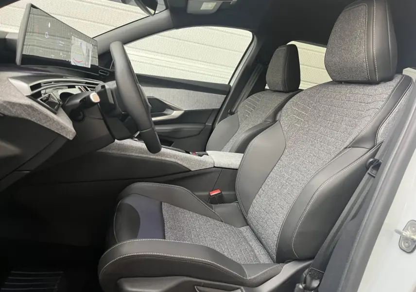 Vue intérieure côté conducteur du Peugeot 5008 Hybrid 145 Allure 2025 avec sièges tissu et cuir gris, volant multifonctions cuir.
