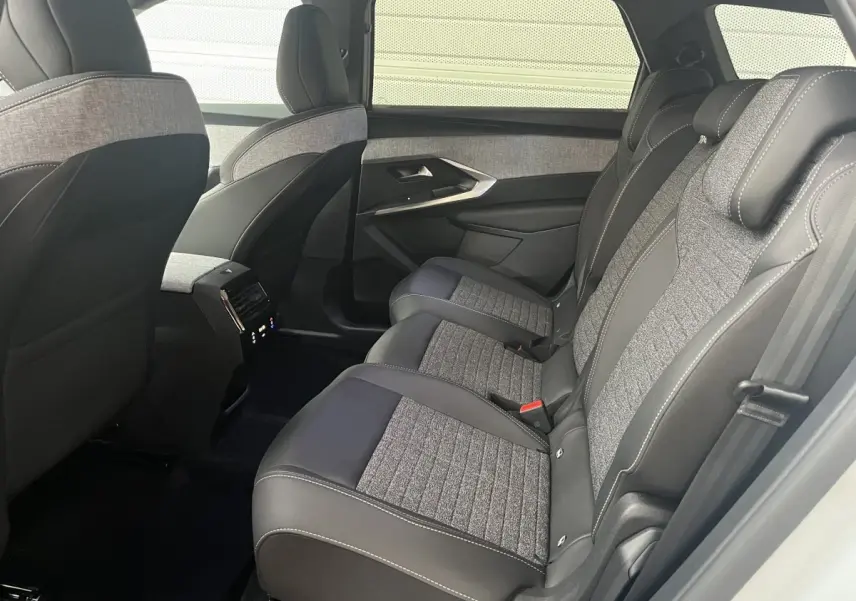 Vue intérieure côté droit sur la banquette arrière gris foncé et tissu clair du Peugeot 5008 Hybrid 2025 blanc.